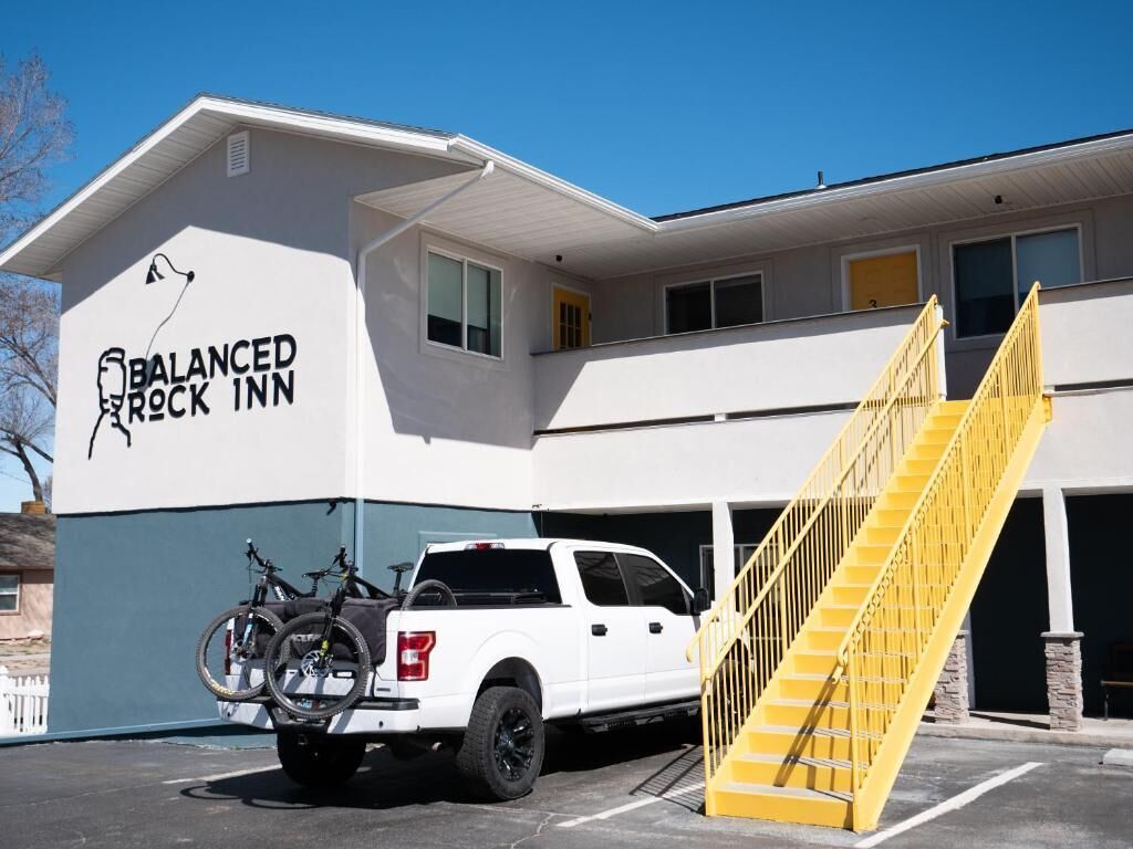 A white truck parked in front of a building with a sign reading "BALANCED ROCK INN".