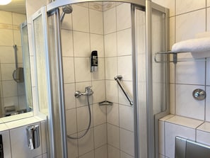 Een moderne douche met een handdouche, een handdouche en een apparaat voor lichaamsbeharing.