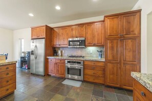 A kitchen with wooden cabinets, stainless steel appliances, and a granite countertop.
