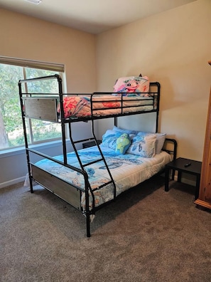 A bunk bed with a window view, a small bedside table, and a nightstand. - Tipsy Turtle | RunningY | Crater Lake | Sleeps 12 (Klamath Falls)