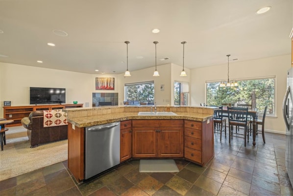 A spacious kitchen with a granite countertop, wooden cabinets, and a built-in dishwasher.
