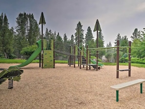 A playground with a slide, climbing structures, and a swing set.