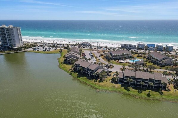 Un hotel costero con varias edificaciones, una playa y una extensión de agua.