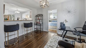 A modern kitchen with bar stools, a dining table, and a chandelier. - Charming 3-bedroom house in cool Hapeville neighborhood (Hapeville)