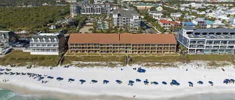 A beachfront hotel with multiple stories, a sandy beach, and ocean views.