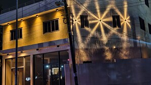 A building with a modern architectural design, featuring large windows and a prominent light display on the facade. - Cozy 1-bedroom apartment in amazing Accra (Accra)
