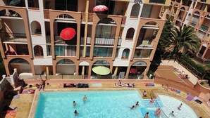 En stor indendørs swimmingpool omgivet af flere altaner med parasoller.