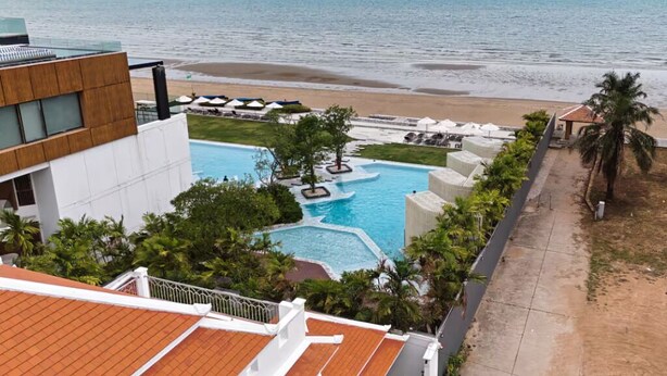 Un resort con piscina, playa y vista al océano.