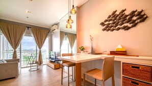 Una sala de estar moderna con comedor, ventanas amplias y un cuadro de peces.
