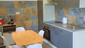 A modern kitchen with a central island, white chairs, and a stone backsplash. - Emma modern suite (2-minute walk from the beach). (Kourou)