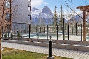 Un bâtiment moderne doté d’une piscine, offrant une vue sur les montagnes et comprenant un espace de stationnement.