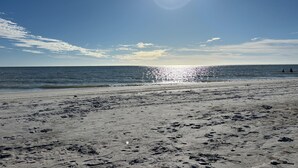 En strand med fotspår och en klar himmel.
