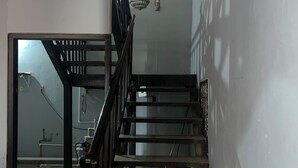 A staircase with a metal railing leading to a landing. There is a visible door at the bottom of the stairs, and a light fixture on the wall. - House 1 centrally located, 8 (up to 14 people) in san blas neighborhood, Comayagua (Comayagua)