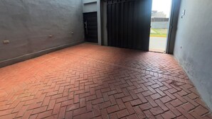 An empty room with a brick floor, a door, and a window. - House 1 centrally located, 8 (up to 14 people) in san blas neighborhood, Comayagua (Comayagua)