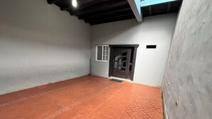 A room with a herringbone-patterned red brick floor, white walls, and a dark wooden ceiling. - House 1 centrally located, 8 (up to 14 people) in san blas neighborhood, Comayagua (Comayagua)