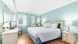 Une chambre à coucher avec un lit, une télévision, un bureau et une table de chevet.