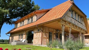 A two-story house with a tiled roof, a covered porch, and a brick exterior. - Landhüüs Oeverdiek by Interhome (Niendorf)