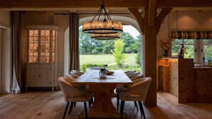 A dining area with a large wooden table, six chairs, and a hanging light fixture. - Landhüüs Oeverdiek by Interhome (Niendorf)