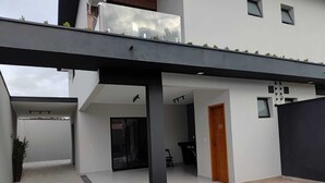 A modern house with a covered patio, a swimming pool, and a small garden area. - Refuge 1 Indaiá Beach Bertioga 150 meters from the sea (Bertioga)