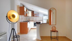 Eine moderne Küche mit Holzausstattung, einer zentralen Kochinsel und einem großen Spiegel.
