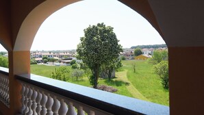 Ein Balkon mit Blick auf einen Baum und eine Wohngegend.
