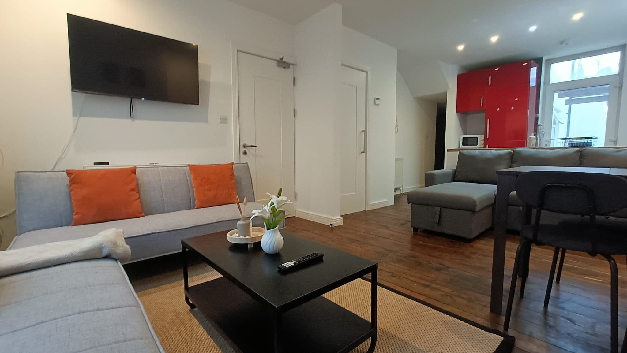 A modern living room with a sofa, coffee table, and a flat-screen TV.