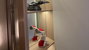 Ein modernes Badezimmer mit Spiegel, Handtuchhalter und Ablagefläche mit einem Föhn.