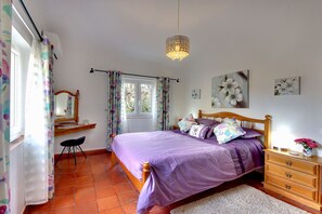 A bedroom with a bed, wooden dresser, and a window with curtains. - Casa Shallo - Holiday Villa with pool in Carvoeiro (Carvoeiro)