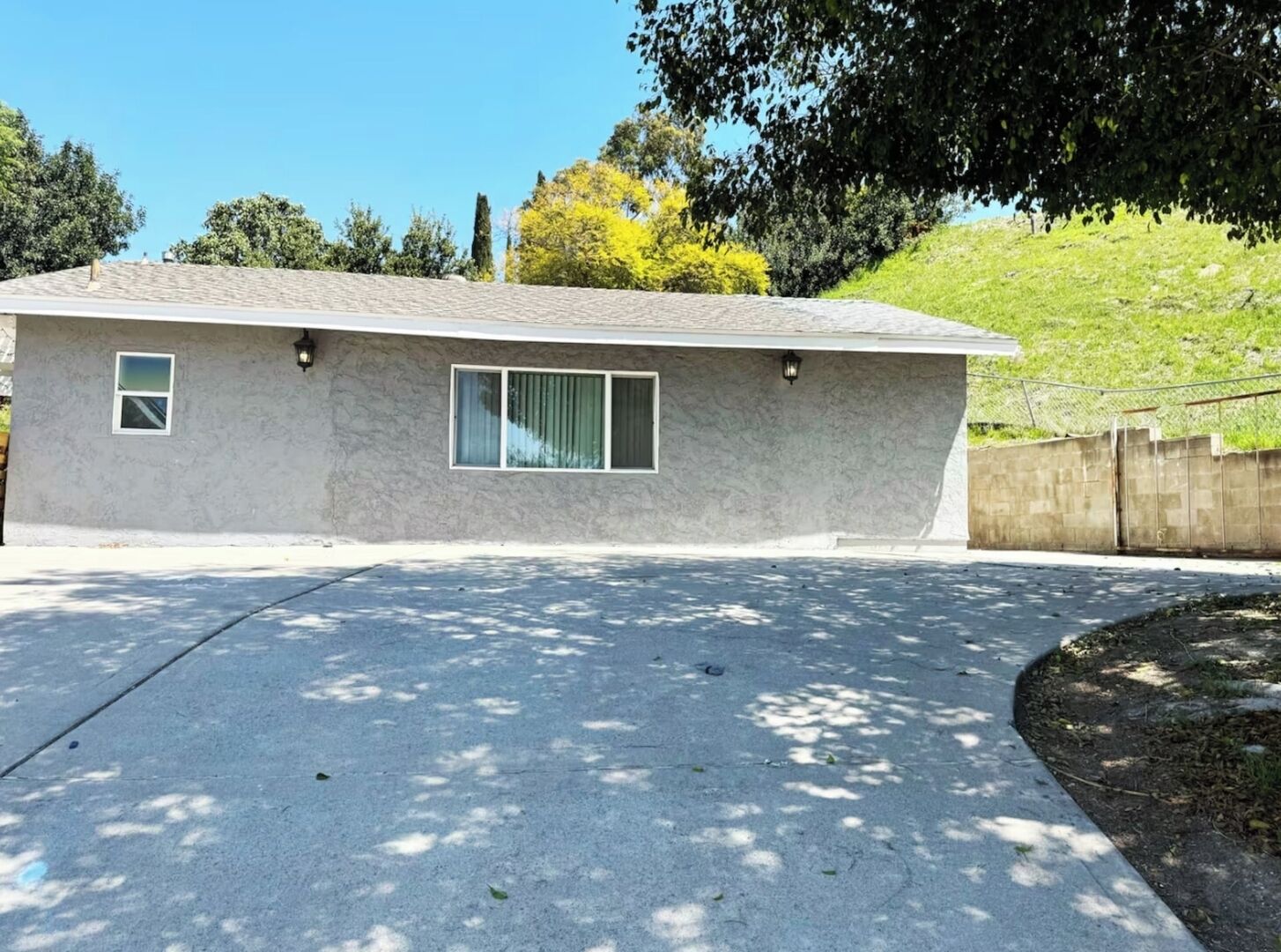 A single-story house with a flat roof, a small front porch, and a paved driveway.