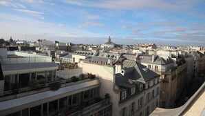 A cityscape with multiple buildings, including a prominent dome structure in the distance. - Top floor studio and view - La Fayette / Opéra (Paris)