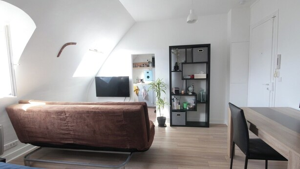 A modern, well-lit room with a bed, a desk, and a TV. - Top floor studio and view - La Fayette / Opéra (Paris)