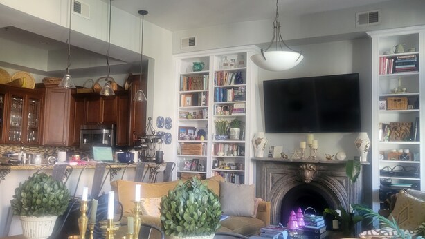 Un ampio soggiorno con camino, televisione e zona pranzo con tavolo e sedie.