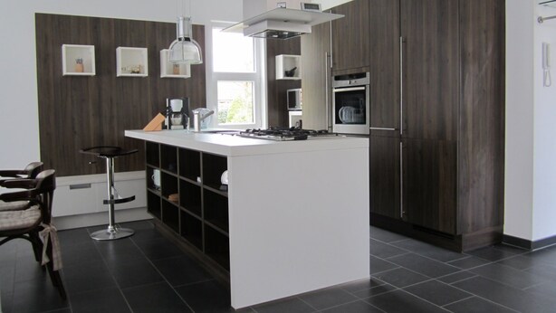 A modern kitchen with a central island, dark wood cabinets, a built-in oven, and a coffee station. - für 4 Personen ca. 165 m² in Mardorf, Niedersachsen (Steinhuder Meer) by Interhome (Mardorf)