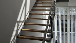 A staircase with wooden steps and metal railings, leading to a balcony with white railings and a view of the sky. - für 4 Personen ca. 165 m² in Mardorf, Niedersachsen (Steinhuder Meer) by Interhome (Mardorf)