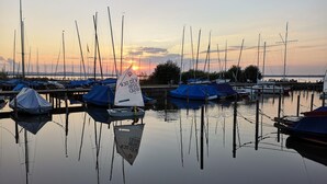 A marina with multiple sailboats docked at calm water during sunset. - für 4 Personen ca. 165 m² in Mardorf, Niedersachsen (Steinhuder Meer) by Interhome (Mardorf)