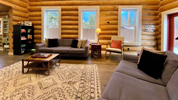 A log cabin interior with a cozy living area, a fireplace, and large windows. - Walk to Lake, Downtown, Restaurants and Shops- Grand Mountain Haven (Grand Lake)