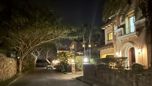 A nighttime view of a residential street with houses on either side. - Chivani modern private pool villa with garden in Na Jomtien Pattaya (Tambon Na Chom Thian)