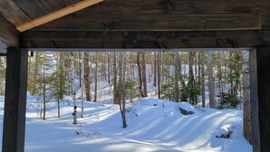 Une cabane en bois avec vue sur une forêt enneigée.