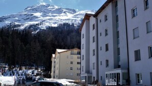Ein Gebäude mit vielen Fenstern und einem schneebedeckten Berg im Hintergrund.