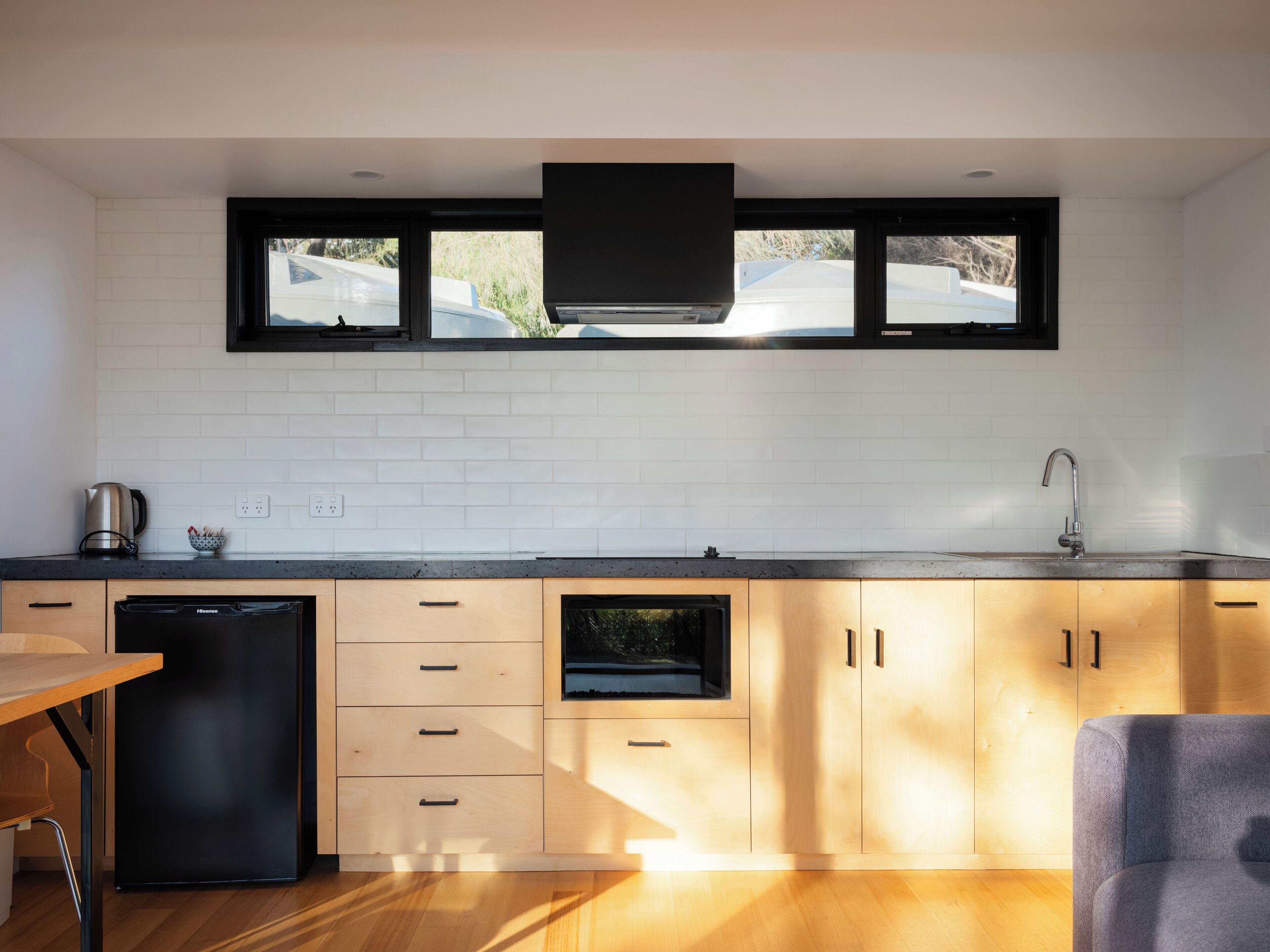 Een moderne keuken met een vaatwasser, een spoelbak en een raam met uitzicht op een straat.