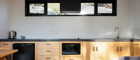 Een moderne keuken met een vaatwasser, een spoelbak en een raam met uitzicht op een straat.