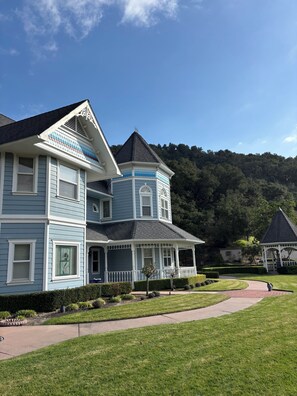 A two-story house with a wrap-around porch and a tower section.