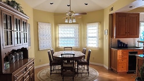 A dining area with a round table and chairs, a ceiling fan, and wooden cabinets. - Beautiful 5-bedroom house in rural San Luis Obispo near Avila and Pismo Beach (San Luis Obispo)