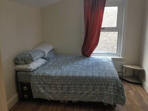 Ein Schlafzimmer mit einem Bett, einem Fenster mit Blick und einer Heizung.