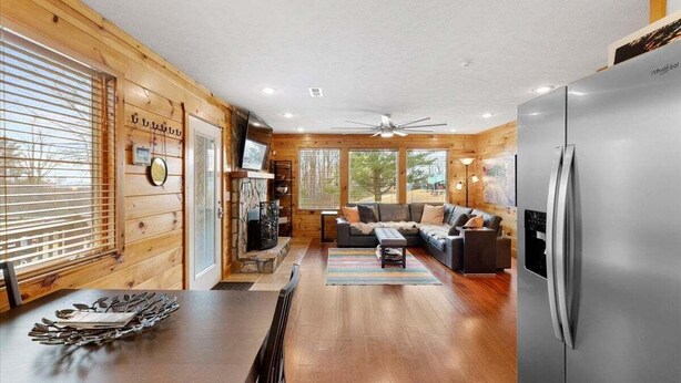 A modern log cabin interior with a dining area, living room, and a large refrigerator. - Stunning Mountain Retreat! Packed with Fun! Air Hockey Table! - Two Sisters Chalet (Fancy Gap)