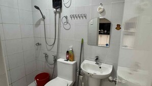 Ein kleines, sauberes Badezimmer mit Toilette, Bidet, Waschbecken und Dusche.