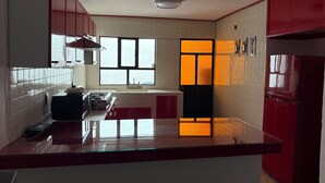 A kitchen with red cabinets, a gas stove, and a window with a view. - Spacious, comfortable and centrally located house. (Ciudad de Apizaco)