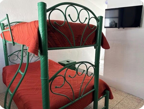 A bunk bed with green metal railings and red bedding. - Spacious, comfortable and centrally located house. (Ciudad de Apizaco)