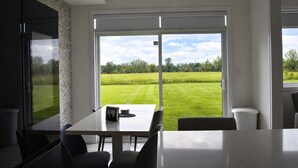 Een moderne keuken met een groot raam, een eettafel en stoelen.