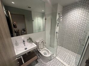 A modern bathroom with a glass-enclosed shower, a white sink, and a toilet. - City View Condo - Pool, Gym – BTS Talat Phlu (Bang Chak, Phra Khanong)